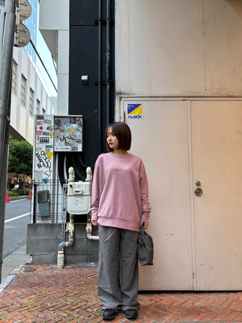 ピンク系のスウェット、ブラック系のショルダーバッグを着用したレディースの秋コーディネートの3枚目の写真