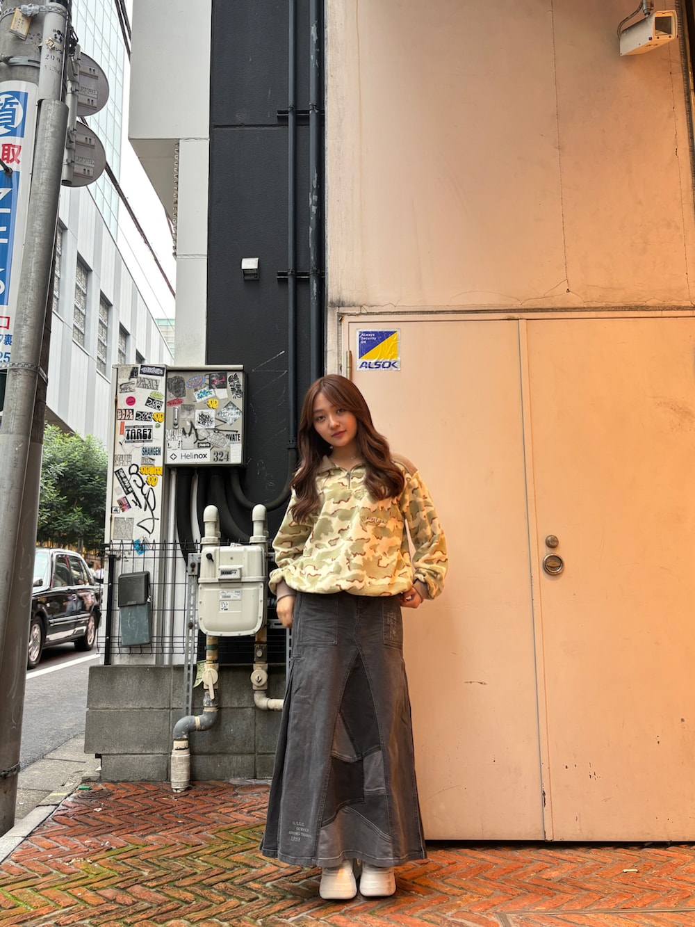 ブラック系のデニムスカート、ベージュ系のTシャツ/カットソーを着用したレディースの秋コーディネートの3枚目の写真