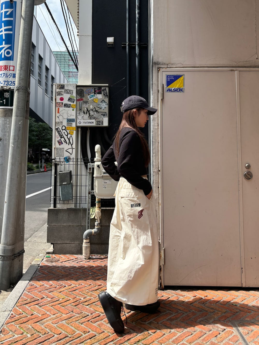 ホワイト系のスカート、ブラック系のTシャツ/カットソーを着用したレディースの夏コーディネートの2枚目の写真