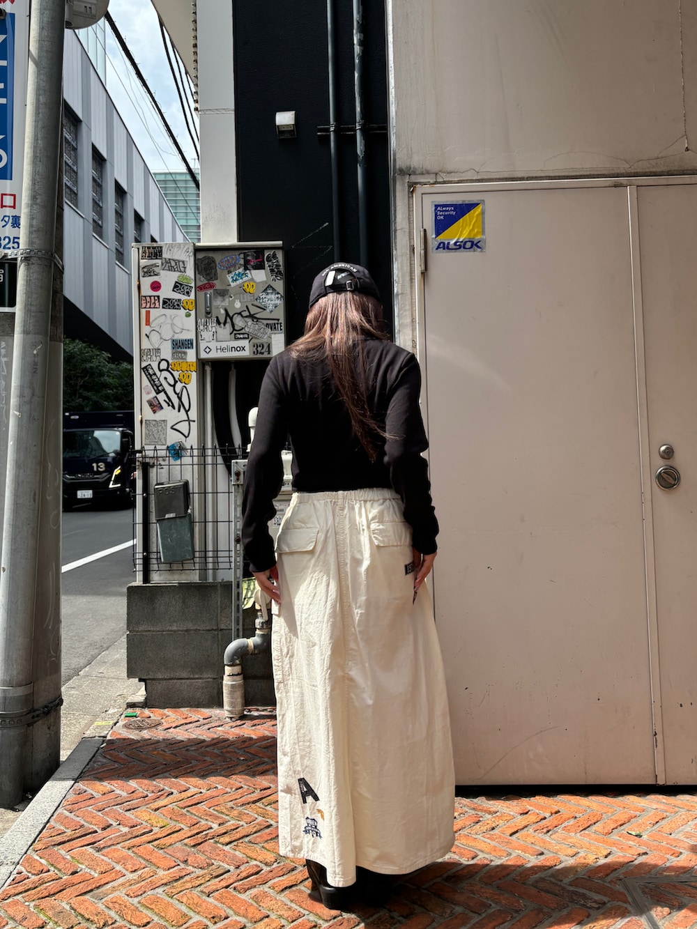 ホワイト系のスカート、ブラック系のTシャツ/カットソーを着用したレディースの夏コーディネートの3枚目の写真
