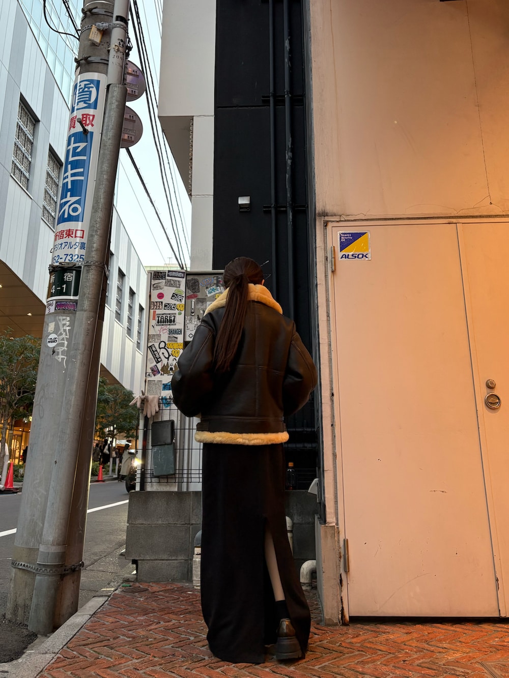 ブラウン系のムートンコートを着用したレディースの冬コーディネートの4枚目の写真