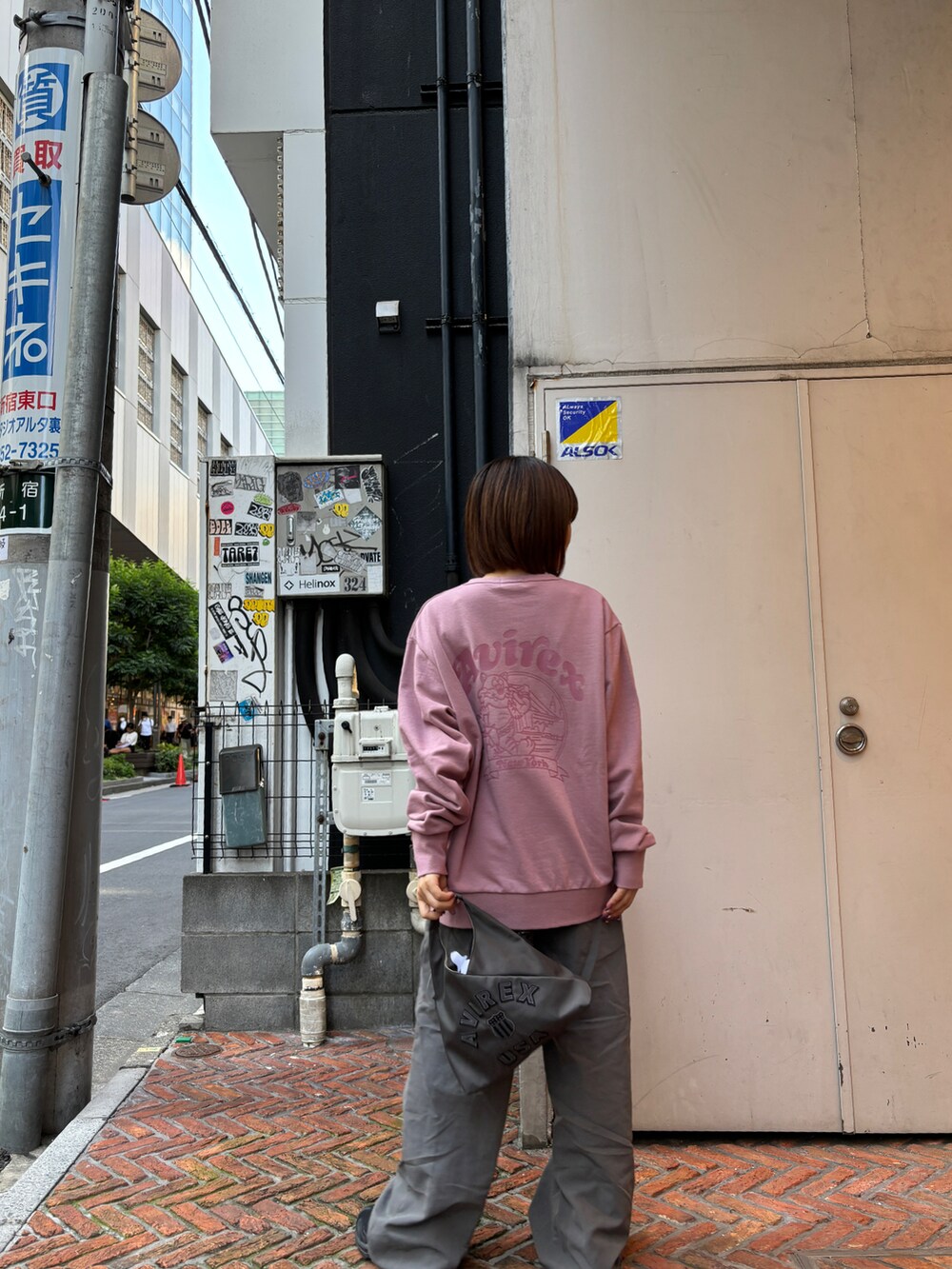 ピンク系のスウェット、ブラック系のショルダーバッグを着用したレディースの秋コーディネートの5枚目の写真