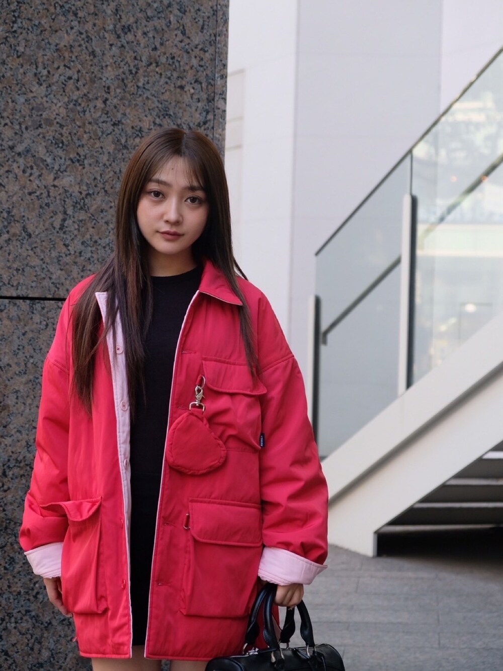 レッド系のナイロンジャケット、ブルー系のキャップを着用したレディースの冬コーディネートの4枚目の写真