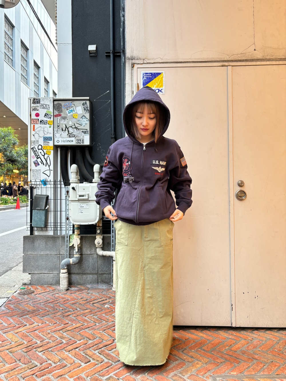 ブルー系のパーカー、グリーン系のスカートを着用したレディースの春コーディネートの3枚目の写真