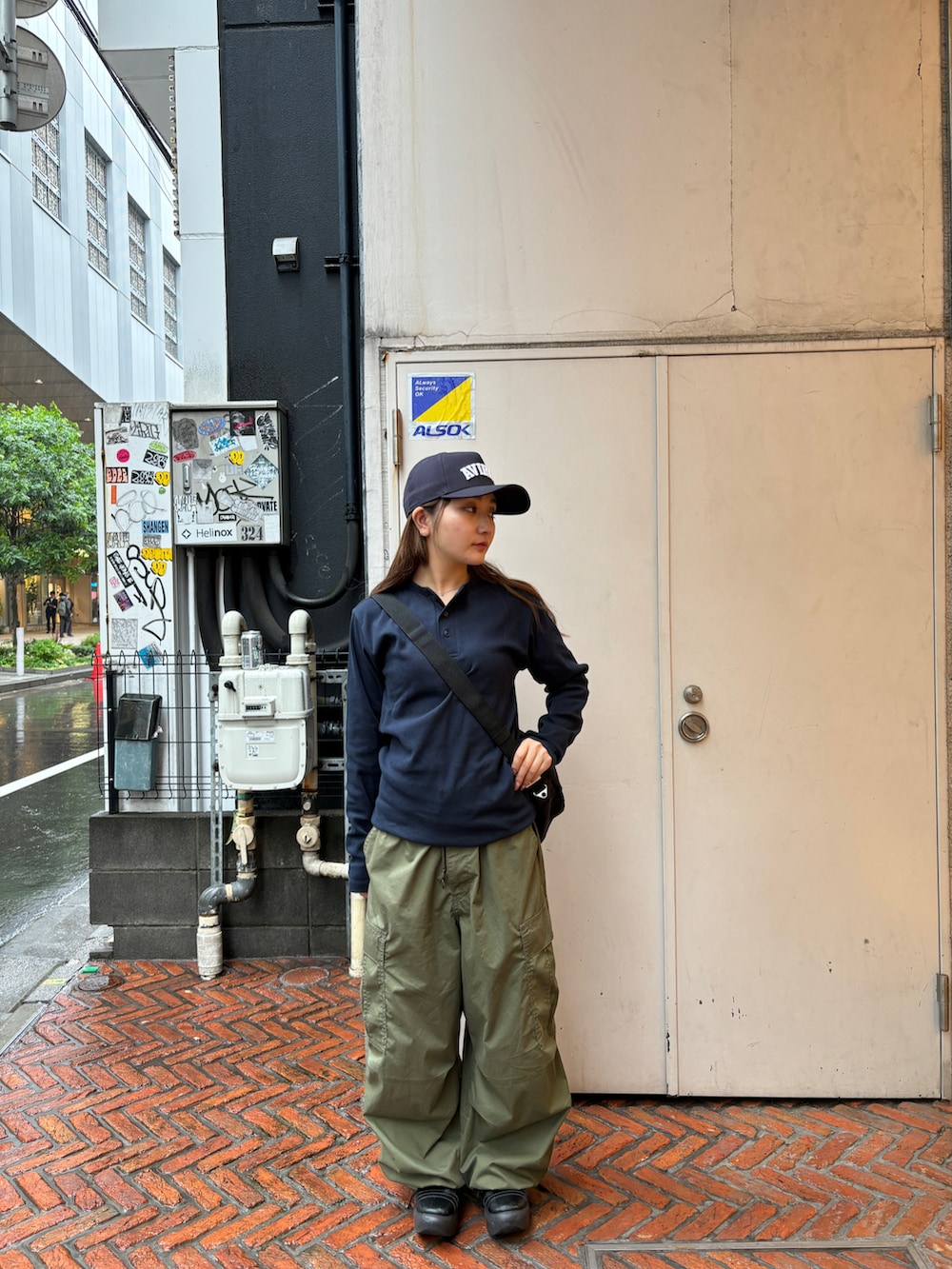 ブラック系のショルダーバッグ、ブルー系のTシャツ/カットソー、ブルー系のキャップを着用したレディースの春コーディネートの2枚目の写真