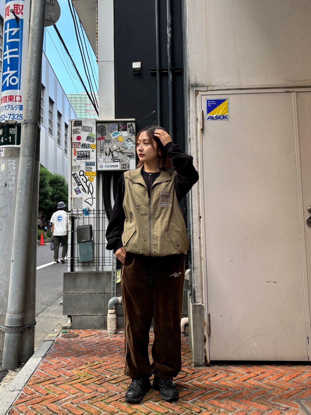 グリーン系のベスト、ブラック系のTシャツ/カットソー、ブラウン系のその他パンツを着用したレディースの秋コーディネートの2枚目の写真