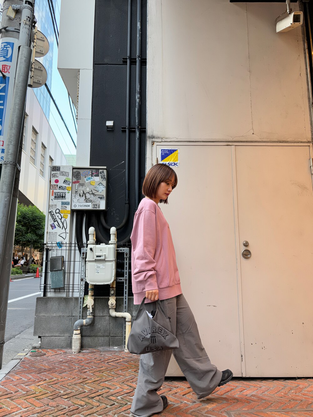 ピンク系のスウェット、ブラック系のショルダーバッグを着用したレディースの秋コーディネートの4枚目の写真