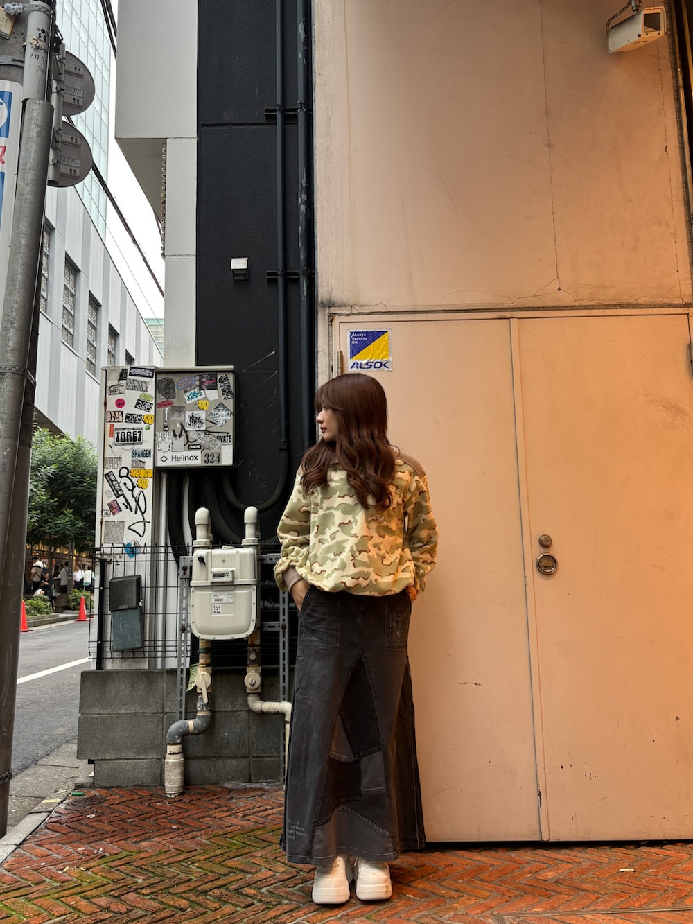 ブラック系のデニムスカート、ベージュ系のTシャツ/カットソーを着用したレディースの秋コーディネートの4枚目の写真