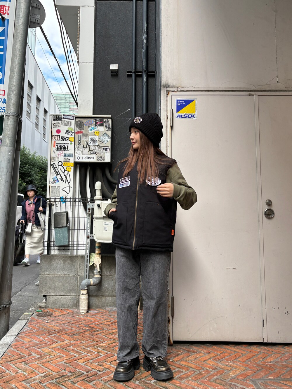 グリーン系のスウェット、ブラック系のニットキャップ/ビーニーを着用したレディースの秋コーディネートの4枚目の写真