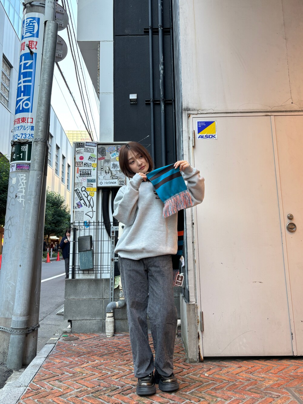 グレー系のスウェット、グレー系のマフラーを着用したレディースの秋コーディネートの3枚目の写真