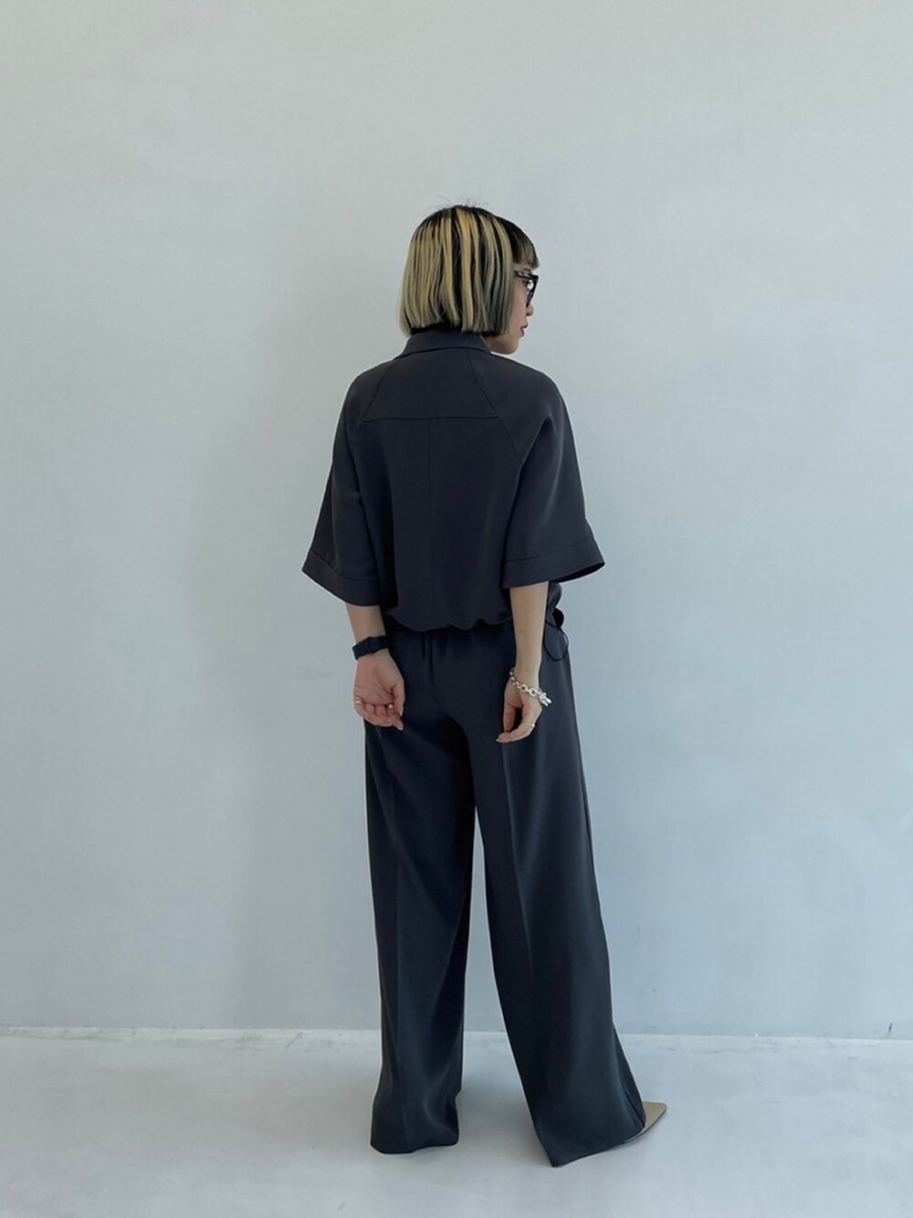 グレー系のシャツ/ブラウス、グレー系のスラックスを着用したレディースの春コーディネートの3枚目の写真