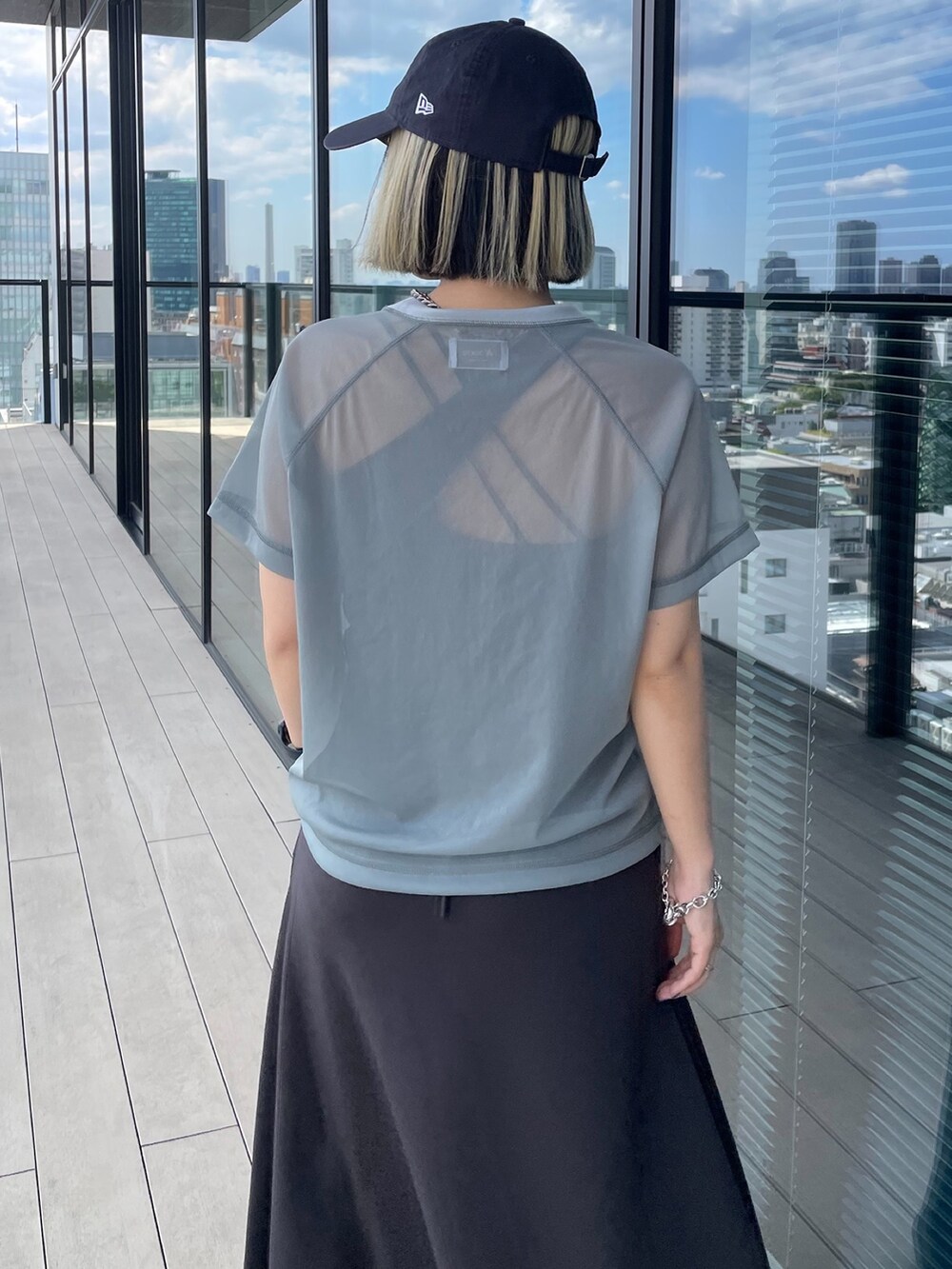 グレー系のTシャツ/カットソー、グレー系のスカート、ブラック系のローファーを着用したレディースの夏コーディネートの5枚目の写真