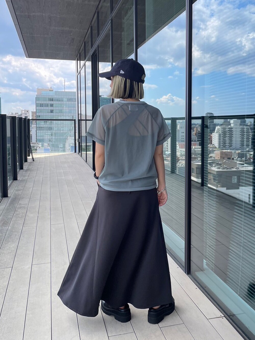 グレー系のTシャツ/カットソー、グレー系のスカート、ブラック系のローファーを着用したレディースの夏コーディネートの3枚目の写真