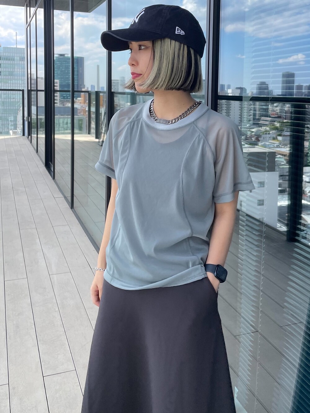 グレー系のTシャツ/カットソー、グレー系のスカート、ブラック系のローファーを着用したレディースの夏コーディネートの4枚目の写真