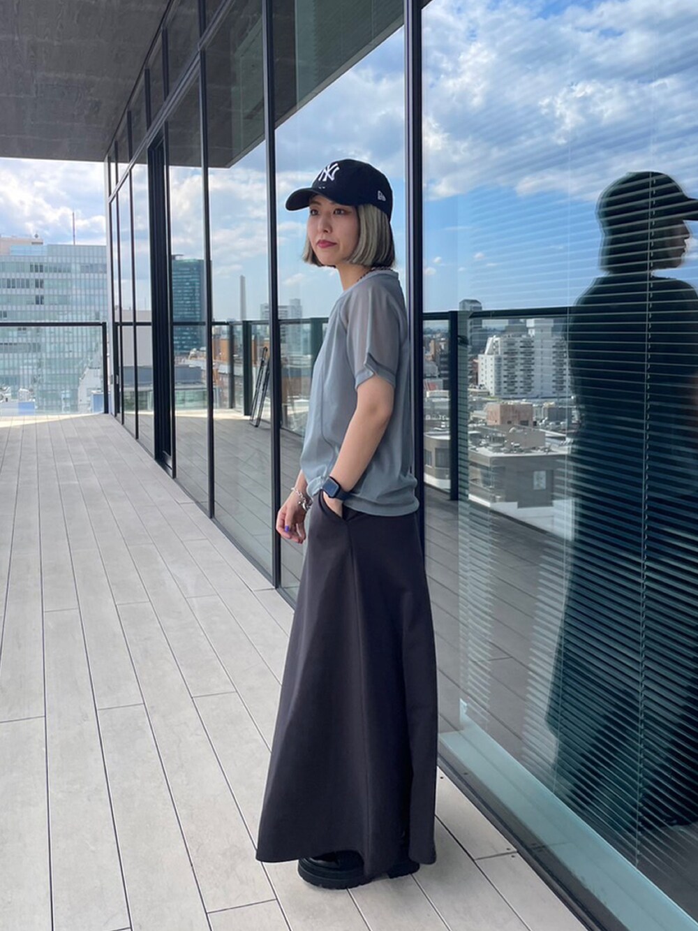 グレー系のTシャツ/カットソー、グレー系のスカート、ブラック系のローファーを着用したレディースの夏コーディネートの2枚目の写真