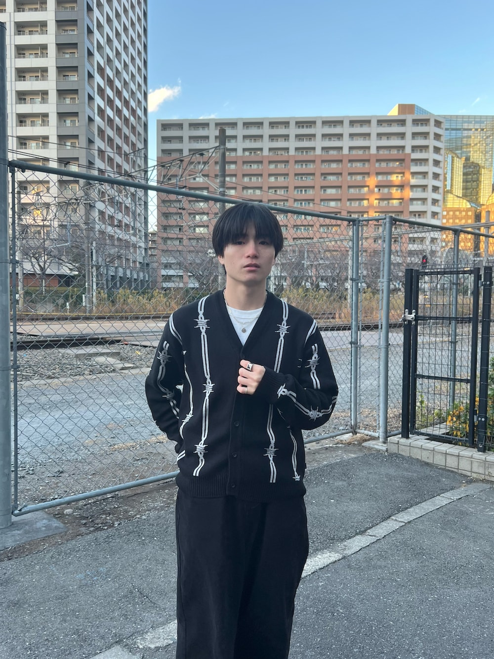 ブラック系のカーディガン/ボレロ、ブラック系のチノパンツ、ブラック系のスニーカーを着用したメンズの春コーディネートの4枚目の写真