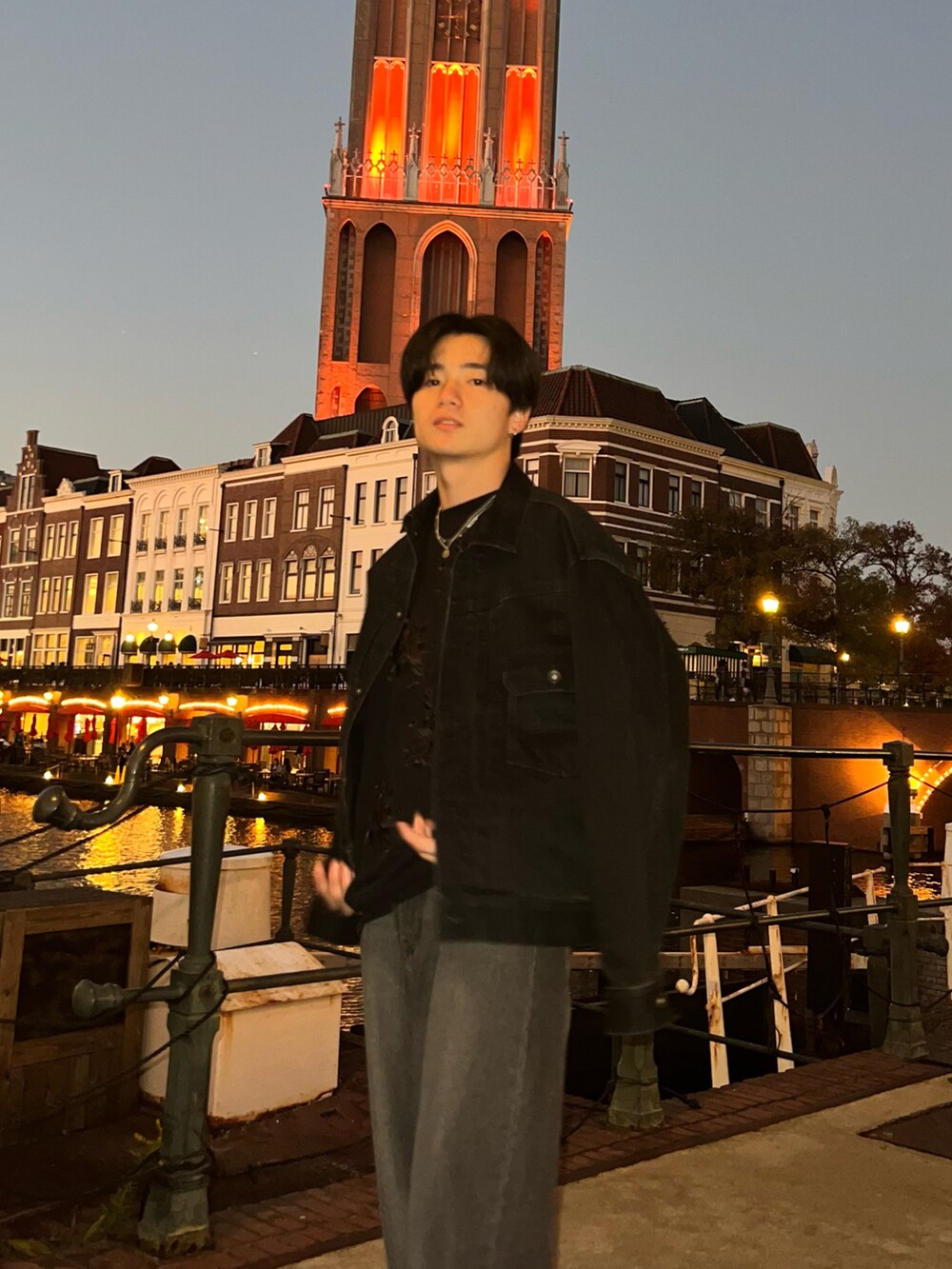 ブラック系のスウェット、ブラック系のデニムパンツ、グレー系のスニーカーを着用したメンズの春コーディネートの2枚目の写真