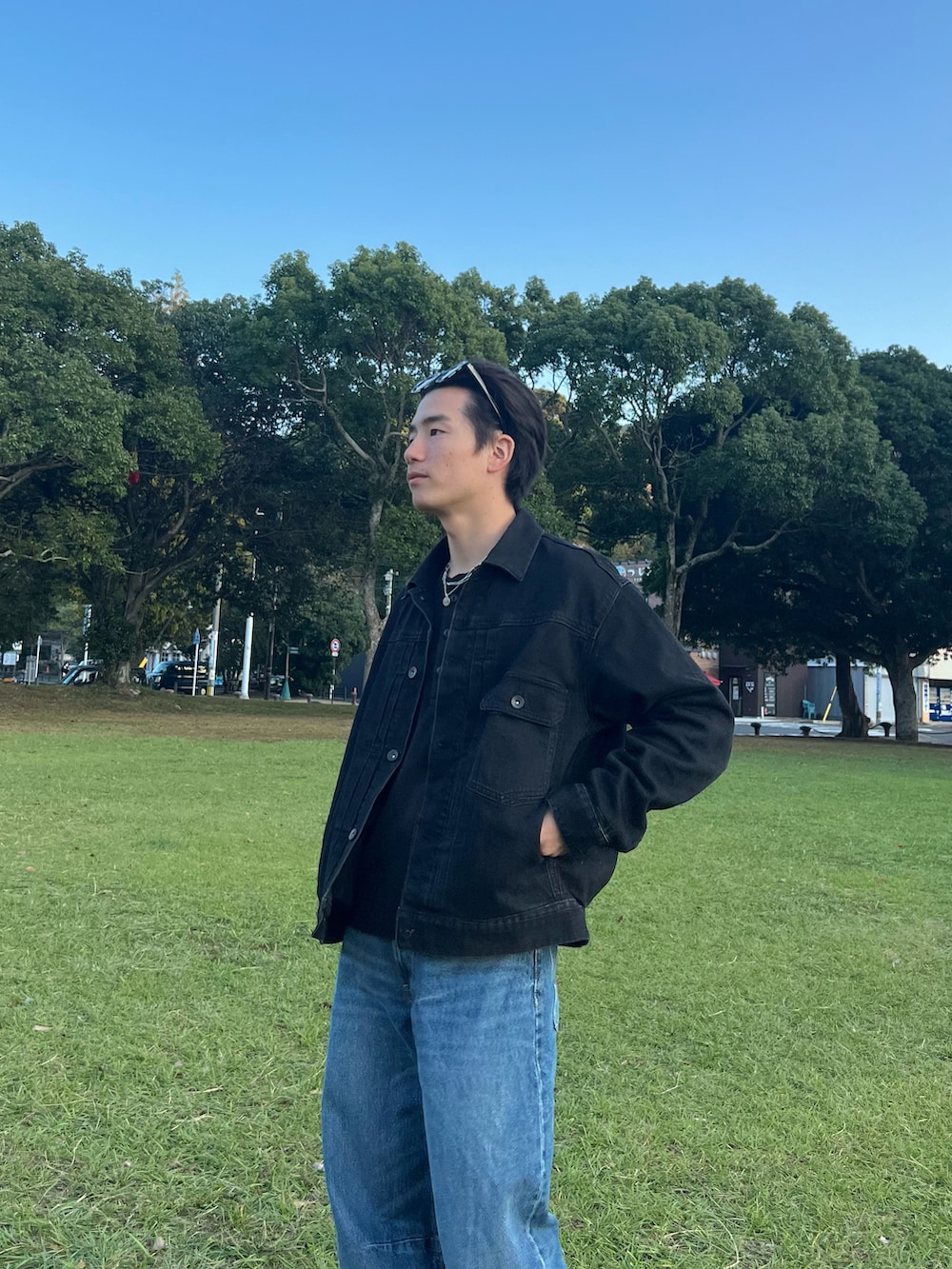 ブラック系のデニムジャケット、ブルー系のデニムパンツ、グレー系のスニーカーを着用したメンズの春コーディネートの5枚目の写真