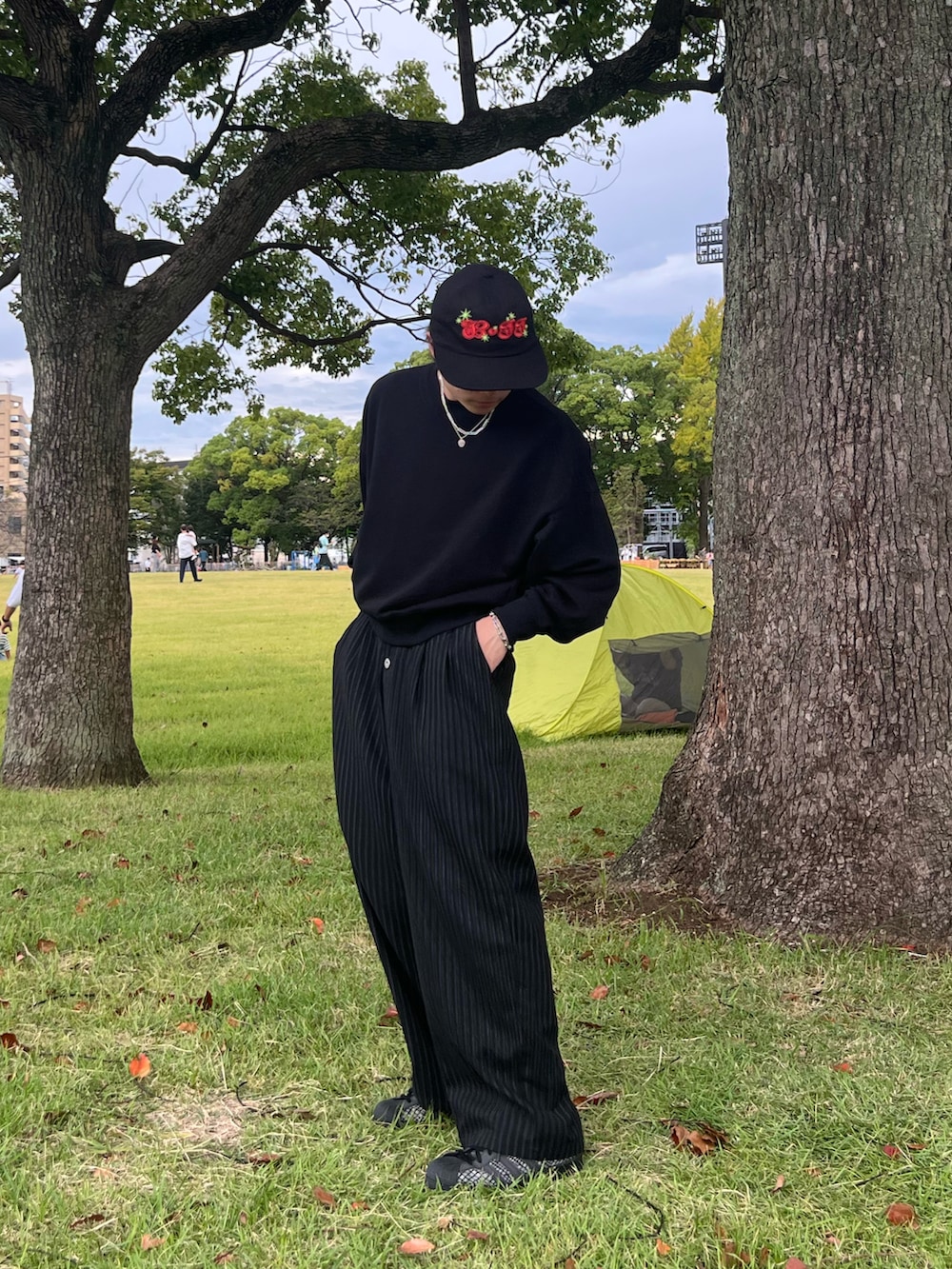 ブラック系のスウェット、ブラック系のスラックス、ブラック系のスニーカーを着用したメンズの春コーディネートの4枚目の写真