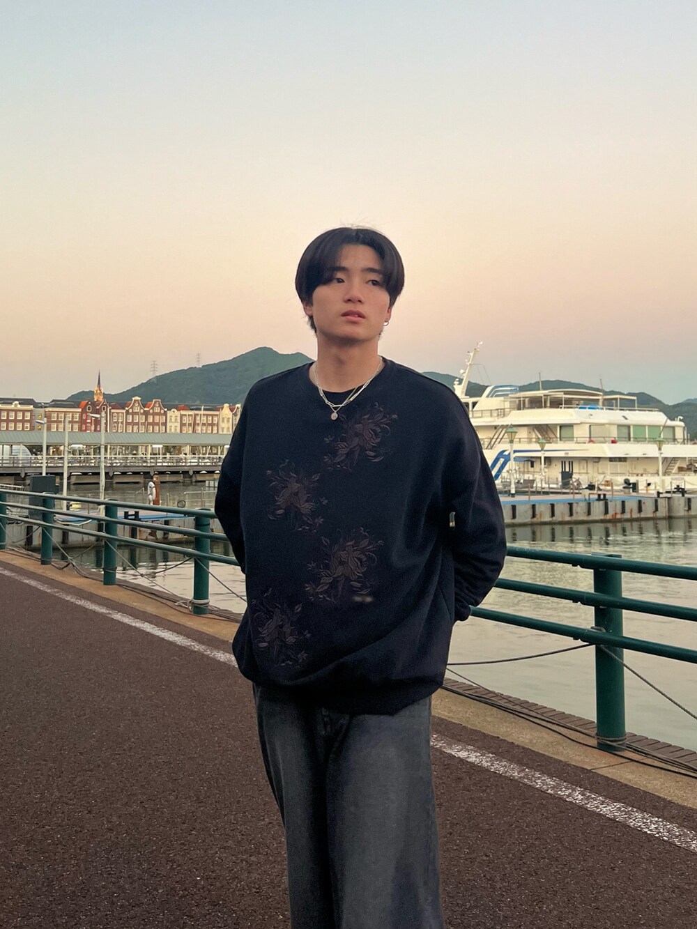 ブラック系のスウェット、ブラック系のデニムパンツ、グレー系のスニーカーを着用したメンズの春コーディネートの4枚目の写真