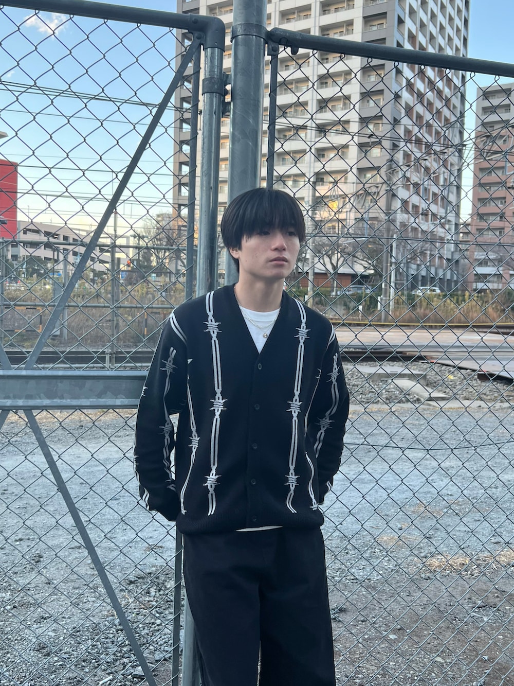 ブラック系のカーディガン/ボレロ、ブラック系のチノパンツ、ブラック系のスニーカーを着用したメンズの春コーディネートの5枚目の写真