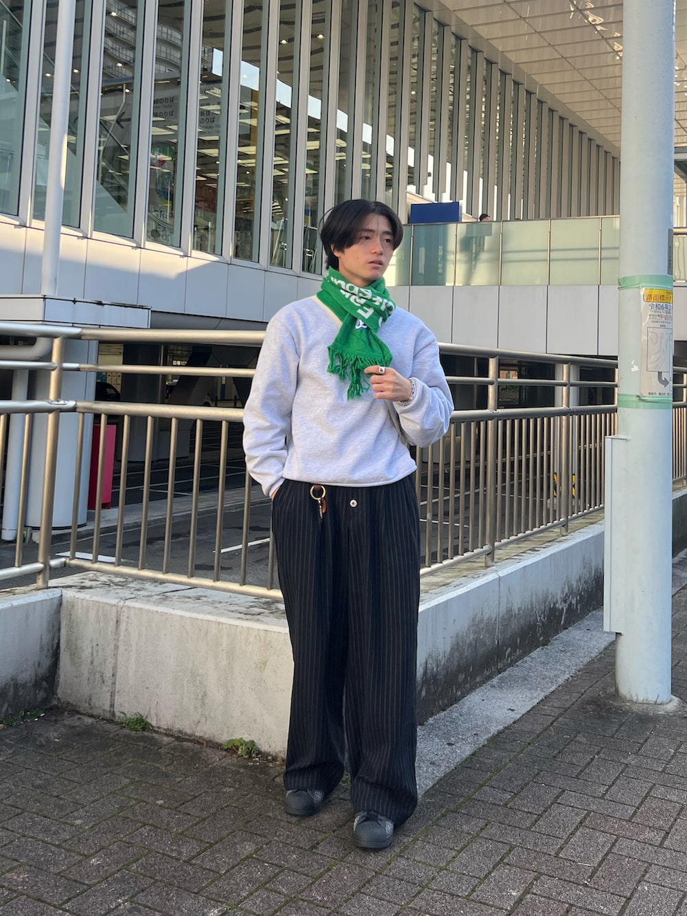 グレー系のスウェット、ブラック系のスラックス、ブラック系のスニーカーを着用したメンズの春コーディネートの5枚目の写真