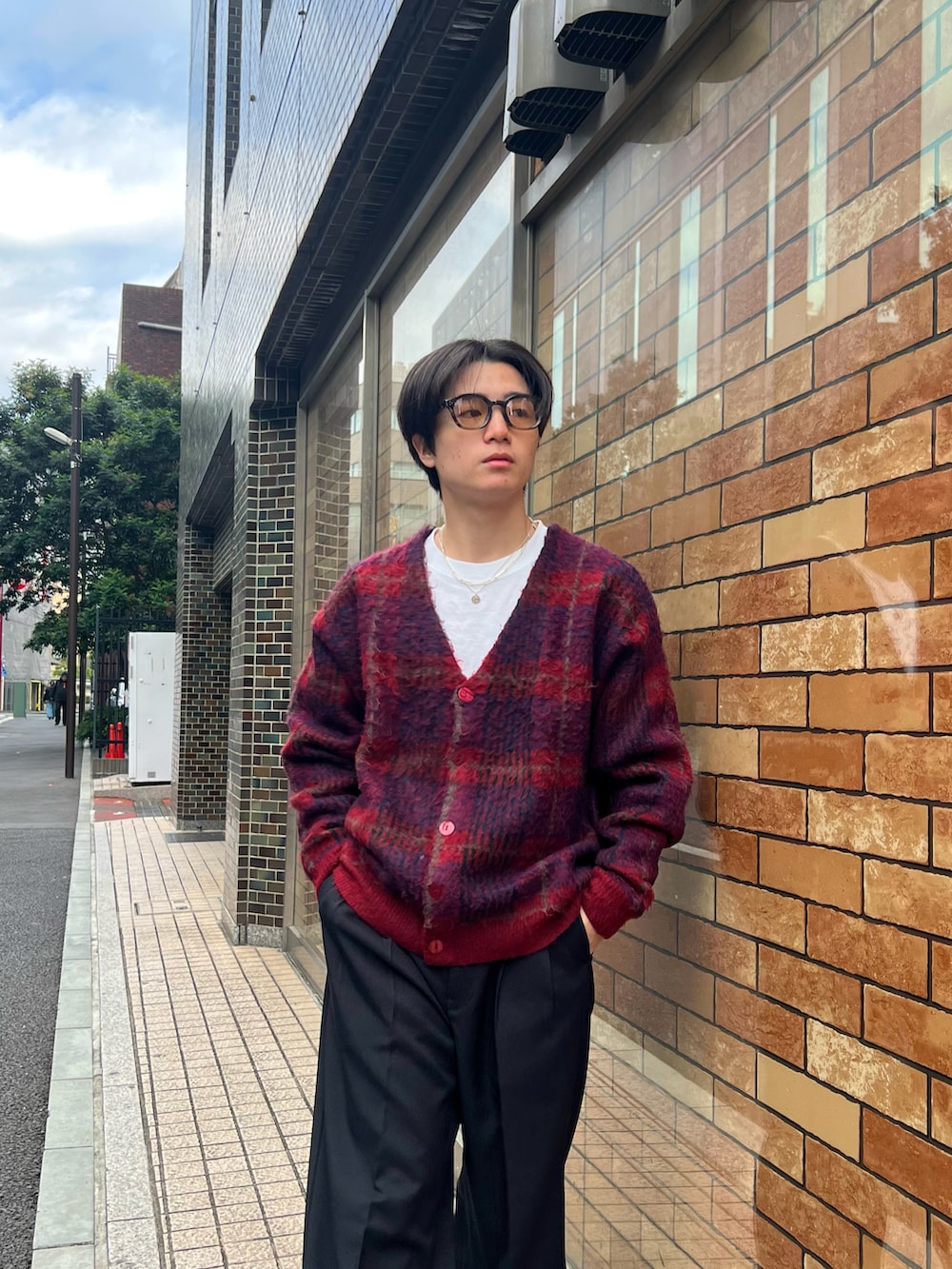 レッド系のカーディガン/ボレロ、ホワイト系のTシャツ/カットソー、ブラック系のスラックスを着用したメンズの春コーディネートの5枚目の写真