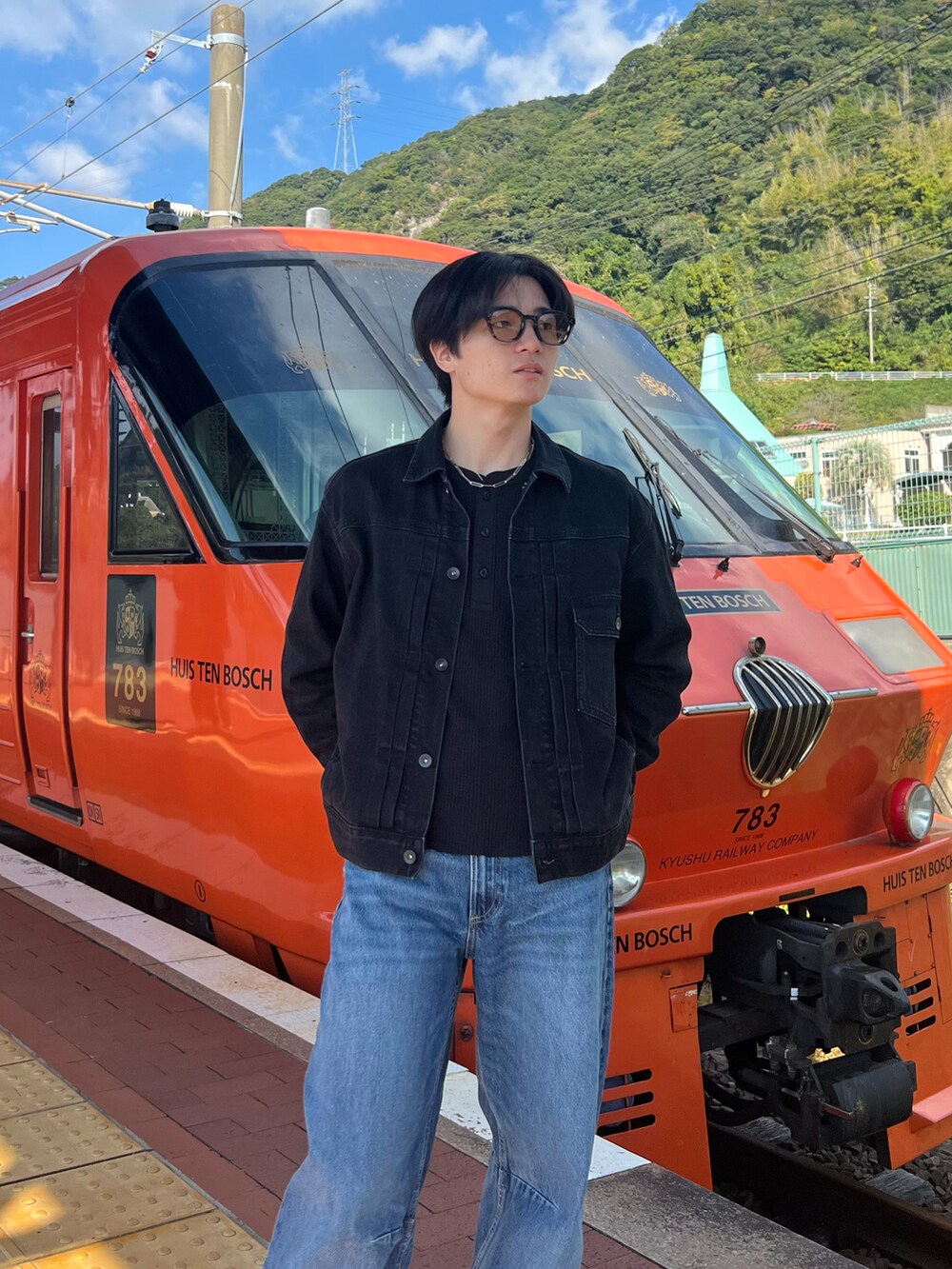 ブラック系のデニムジャケット、ブルー系のデニムパンツ、グレー系のスニーカーを着用したメンズの春コーディネートの2枚目の写真