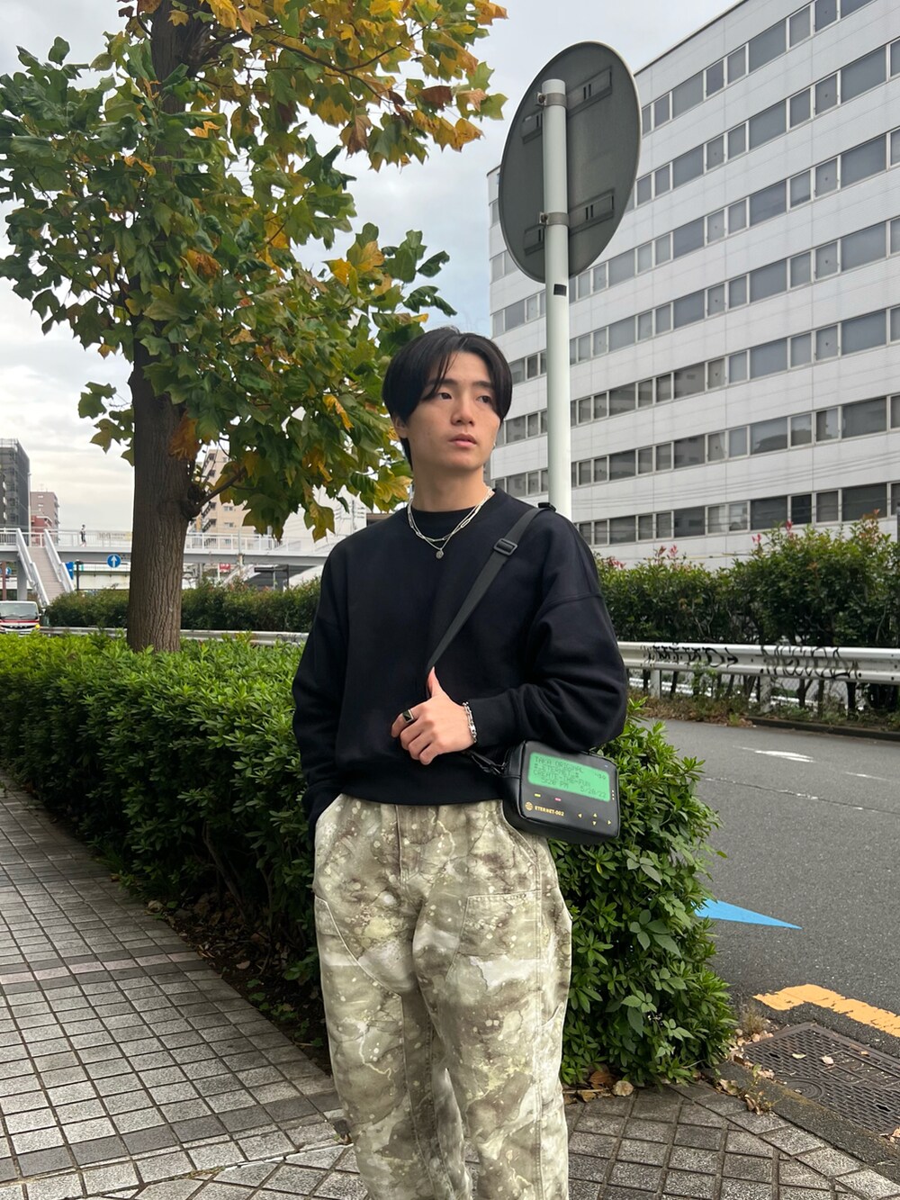 ブラック系のスウェット、グリーン系のチノパンツ、ブラック系のスニーカーを着用したメンズの春コーディネートの4枚目の写真