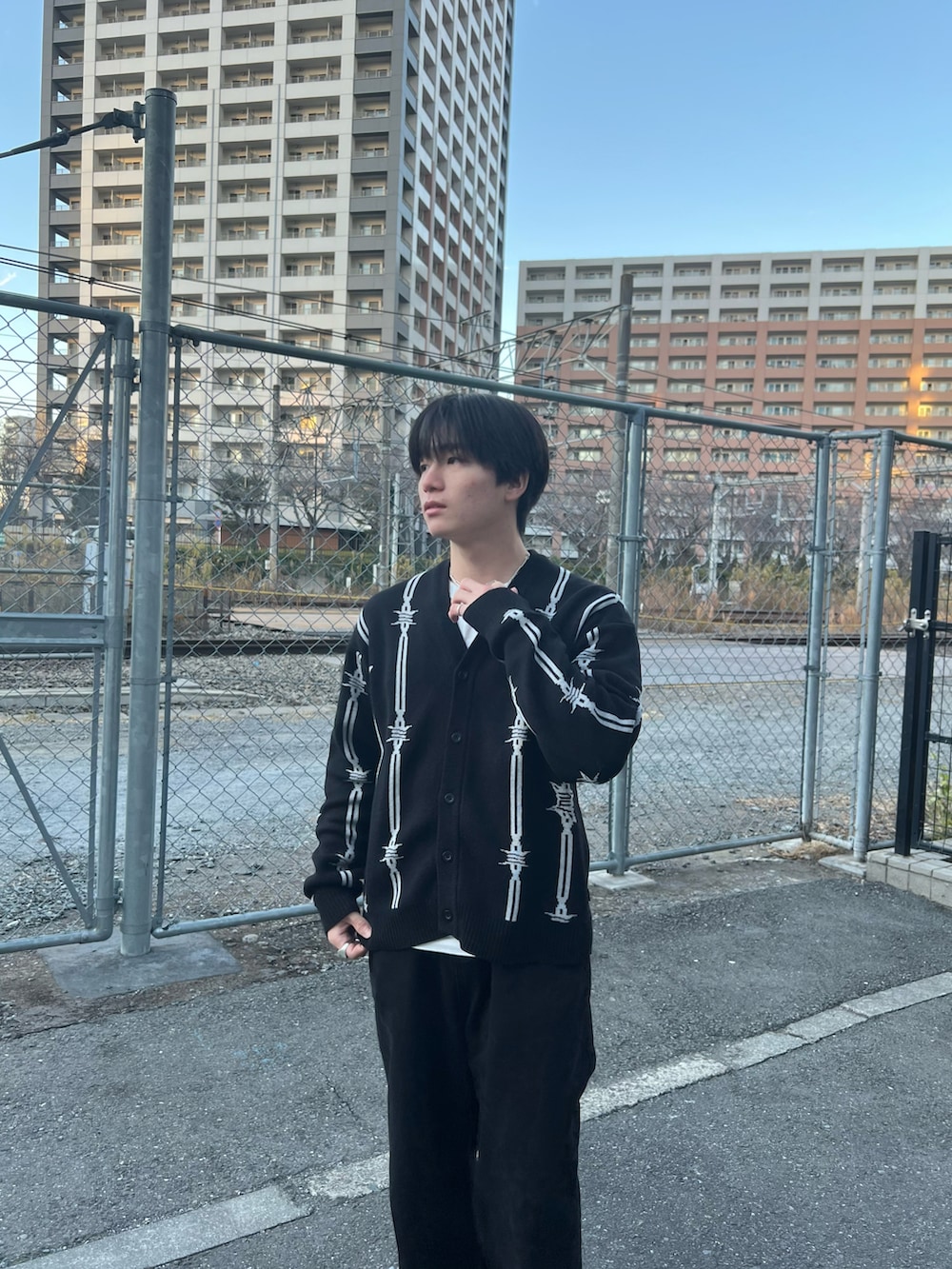 ブラック系のカーディガン/ボレロ、ブラック系のチノパンツ、ブラック系のスニーカーを着用したメンズの春コーディネートの3枚目の写真