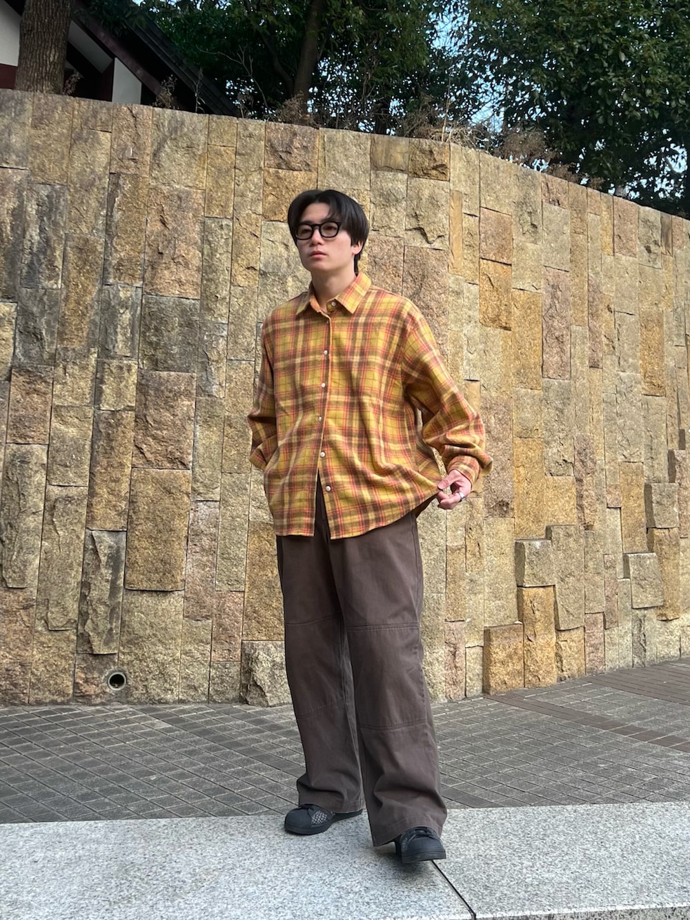 イエロー系のシャツ/ブラウス、ブラウン系のチノパンツ、ブラック系のスニーカーを着用したメンズの春コーディネートの3枚目の写真