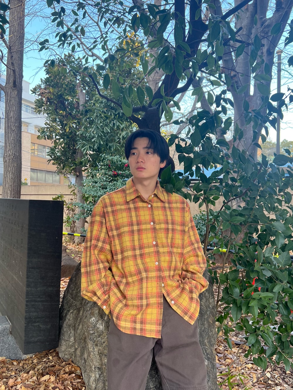 イエロー系のシャツ/ブラウス、ブラウン系のチノパンツ、ブラック系のスニーカーを着用したメンズの春コーディネートの4枚目の写真