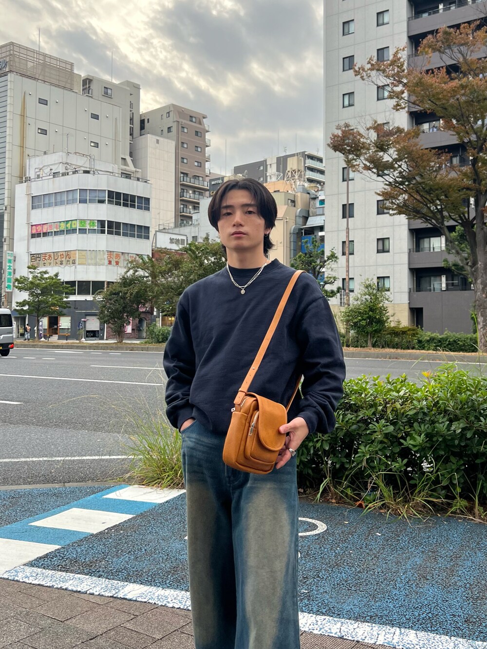 ブルー系のスウェット、ブルー系のデニムパンツ、ブラック系のスニーカーを着用したメンズの春コーディネートの3枚目の写真