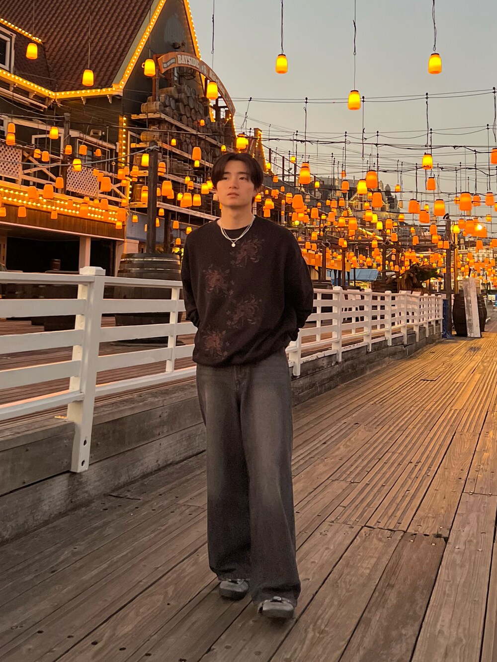 ブラック系のスウェット、ブラック系のデニムパンツ、グレー系のスニーカーを着用したメンズの春コーディネートの3枚目の写真