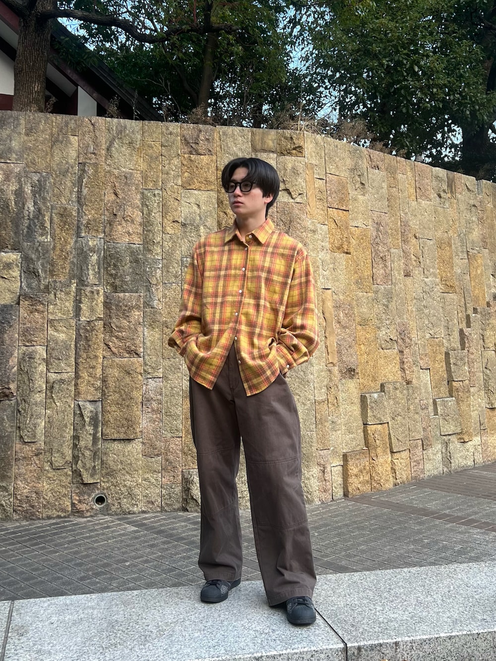 イエロー系のシャツ/ブラウス、ブラウン系のチノパンツ、ブラック系のスニーカーを着用したメンズの春コーディネートの5枚目の写真