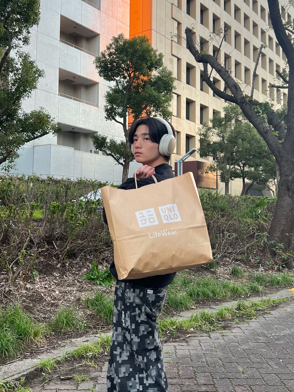 ブラック系のスウェット、ブラック系のチノパンツ、グレー系のスニーカーを着用したメンズの春コーディネートの3枚目の写真