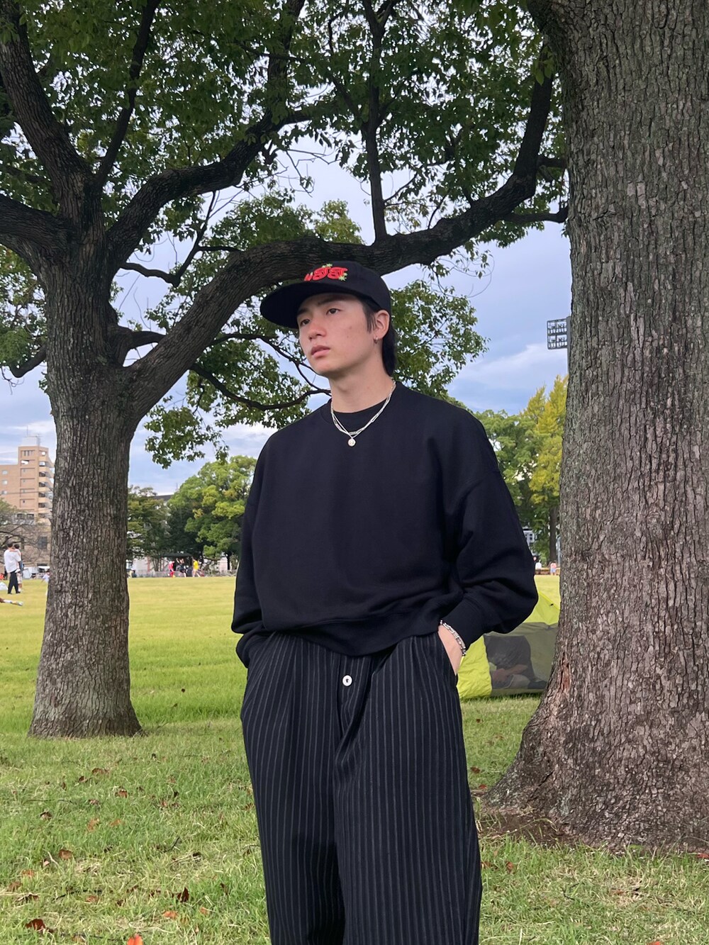 ブラック系のスウェット、ブラック系のスラックス、ブラック系のスニーカーを着用したメンズの春コーディネートの5枚目の写真