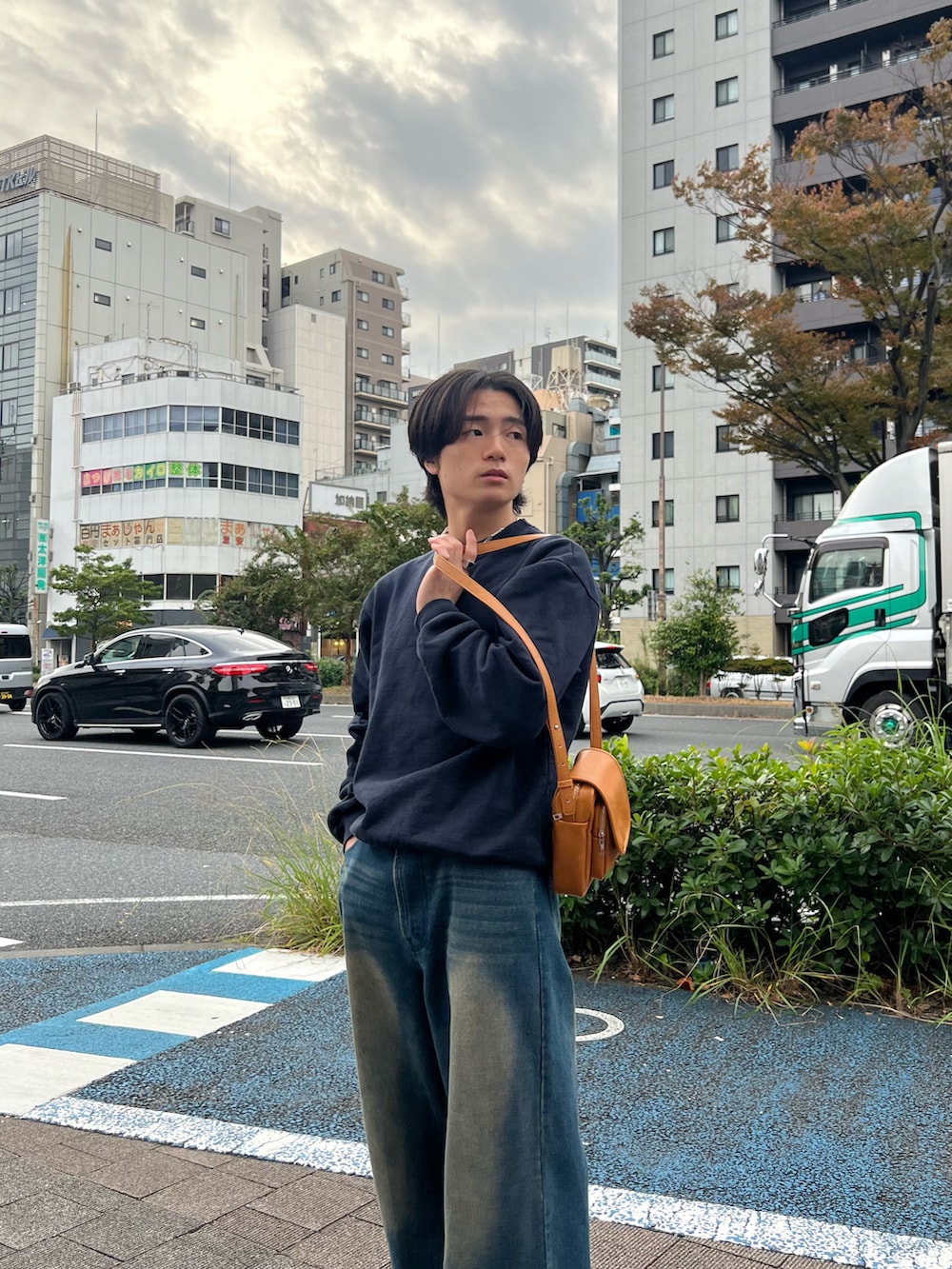 ブルー系のスウェット、ブルー系のデニムパンツ、ブラック系のスニーカーを着用したメンズの春コーディネートの5枚目の写真