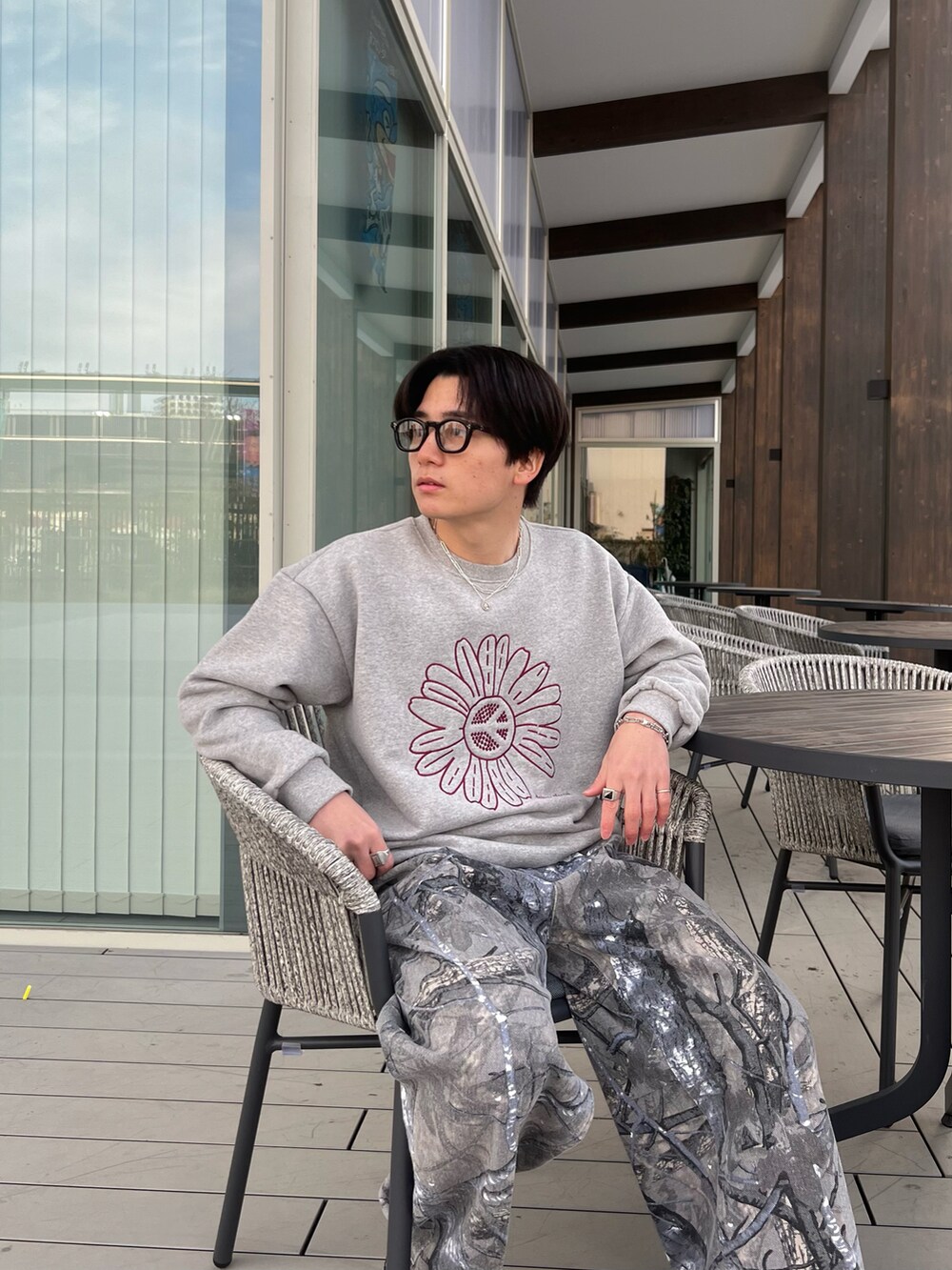 グレー系のスウェット、グレー系のチノパンツ、グレー系のスニーカーを着用したメンズの春コーディネートの3枚目の写真