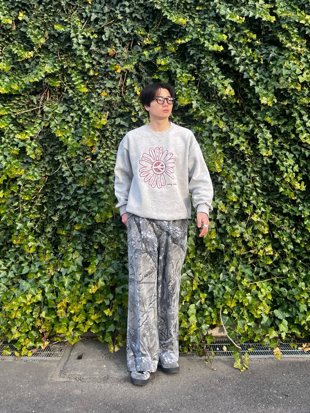 グレー系のスウェット、グレー系のチノパンツ、グレー系のスニーカーを着用したメンズの春コーディネートの4枚目の写真