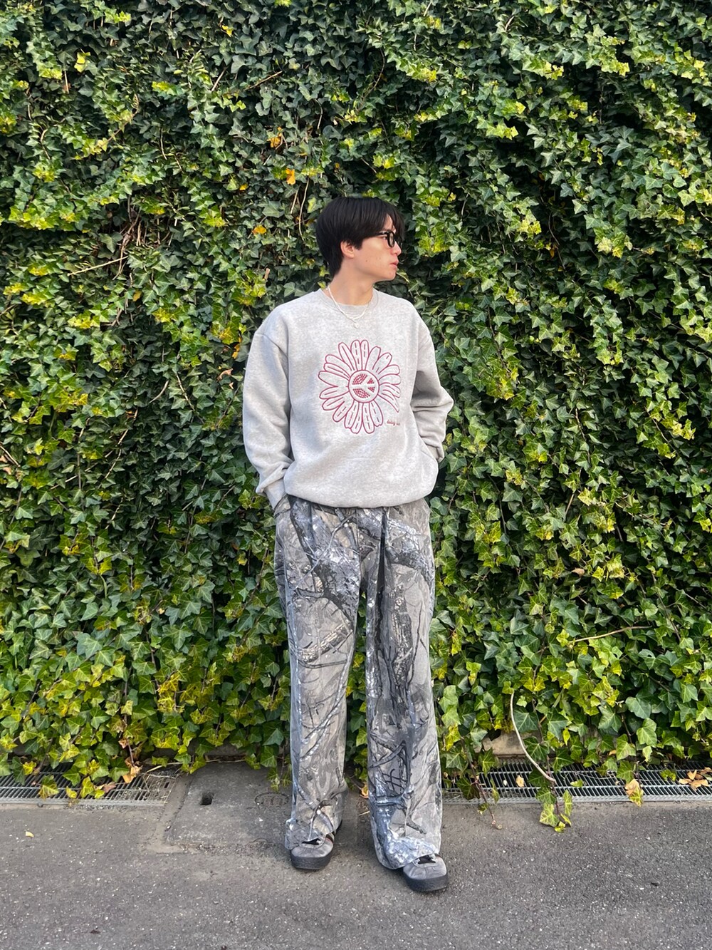 グレー系のスウェット、グレー系のチノパンツ、グレー系のスニーカーを着用したメンズの春コーディネートの2枚目の写真