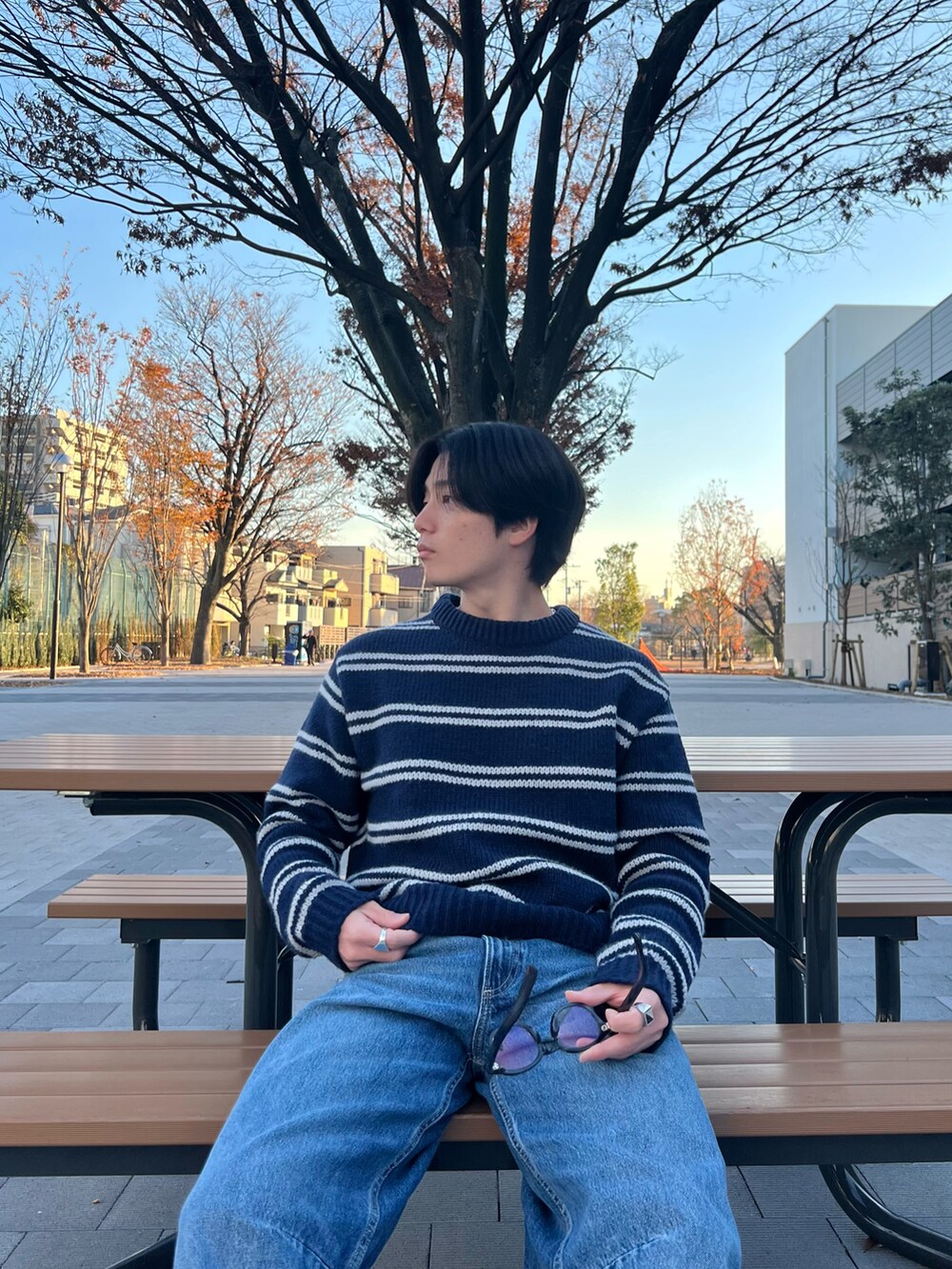 ブルー系のニット/セーター、ブルー系のデニムパンツ、ブラック系のスニーカーを着用したメンズの春コーディネートの3枚目の写真