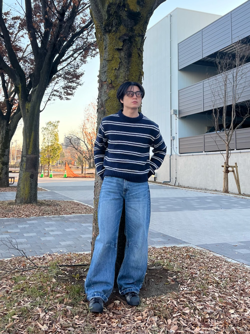 ブルー系のニット/セーター、ブルー系のデニムパンツ、ブラック系のスニーカーを着用したメンズの春コーディネートの5枚目の写真