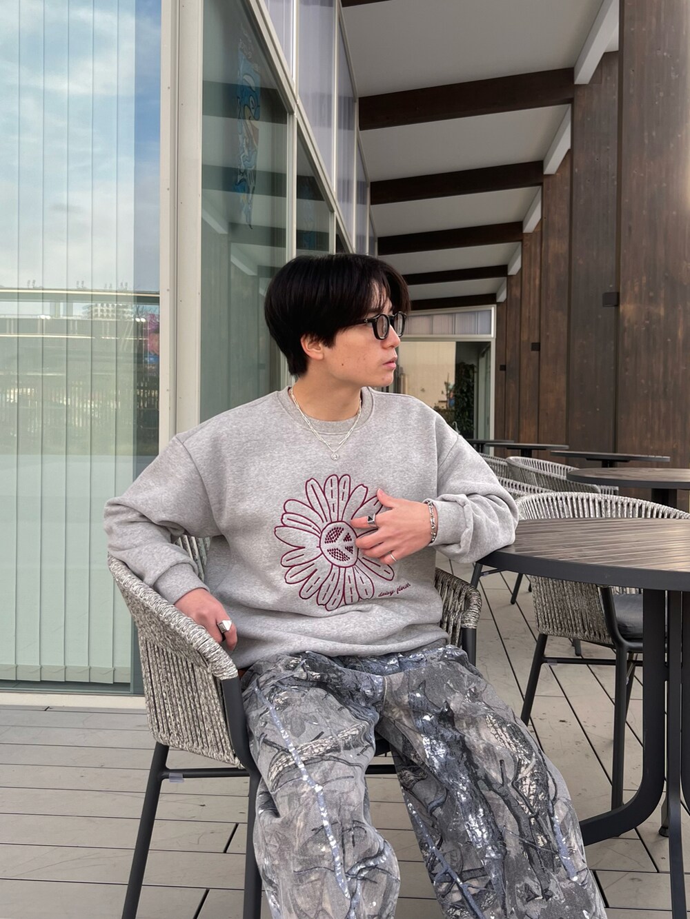 グレー系のスウェット、グレー系のチノパンツ、グレー系のスニーカーを着用したメンズの春コーディネートの5枚目の写真