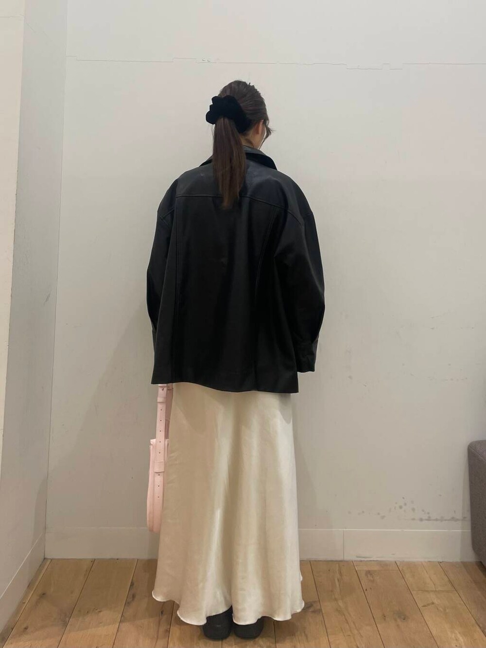 ピンク系のショルダーバッグ、ホワイト系のベスト、ブラック系のその他アウターを着用したレディースの冬コーディネートの3枚目の写真