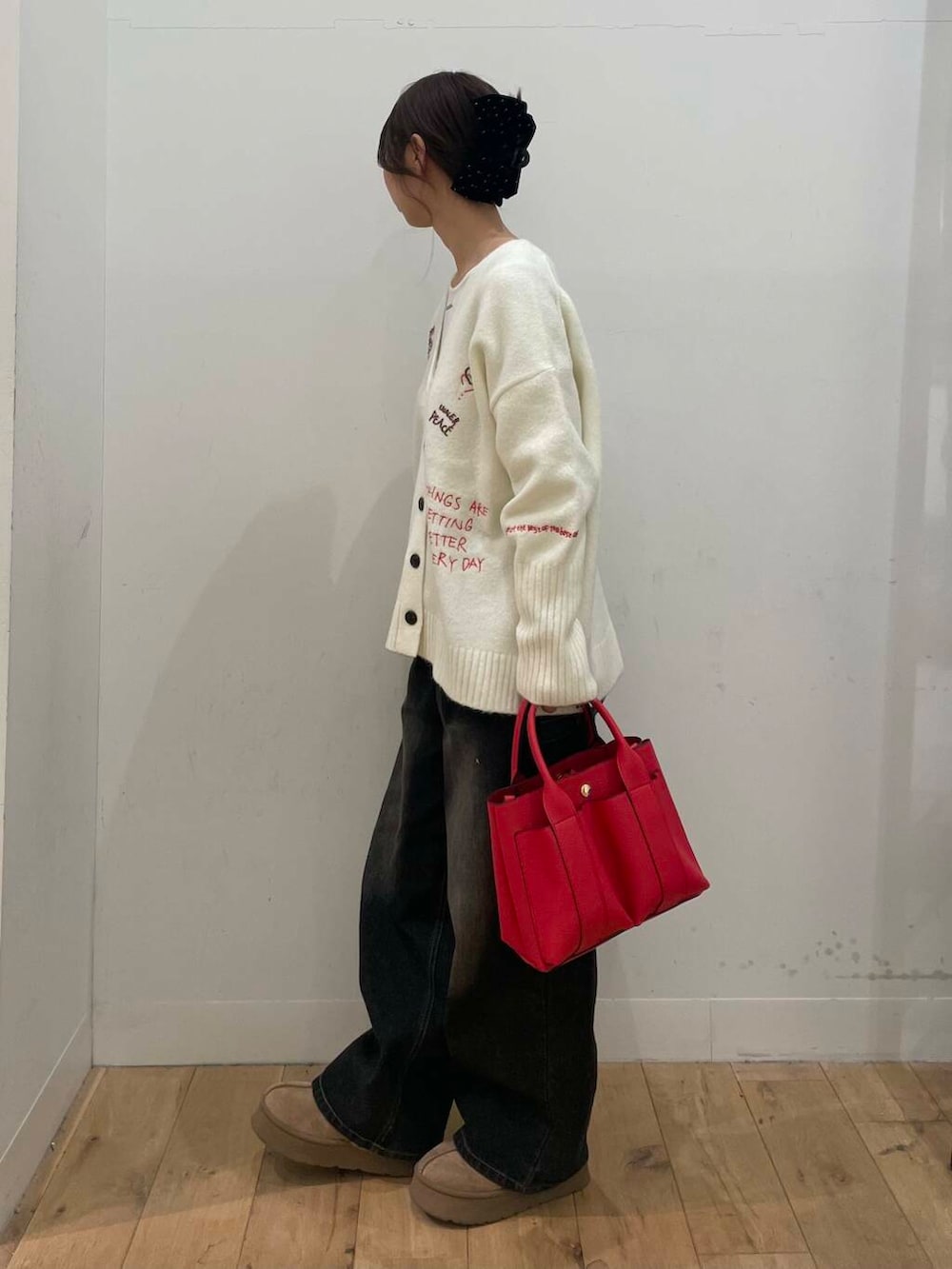 レッド系のトートバッグ、ホワイト系のTシャツ/カットソー、ホワイト系のカーディガン/ボレロを着用したレディースの冬コーディネートの2枚目の写真
