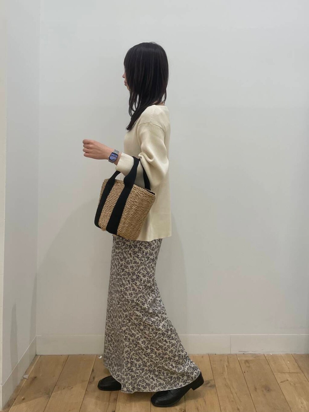 ベージュ系のハンドバッグ、ブラック系のローファー、ホワイト系のカーディガン/ボレロを着用したレディースの春コーディネートの2枚目の写真