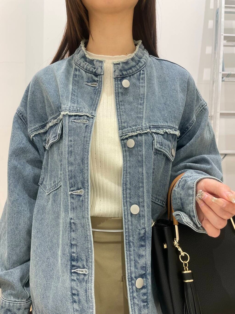 ブラック系のトートバッグ、ブラック系のブーツ、ベージュ系のスカートを着用したレディースの冬コーディネートの4枚目の写真