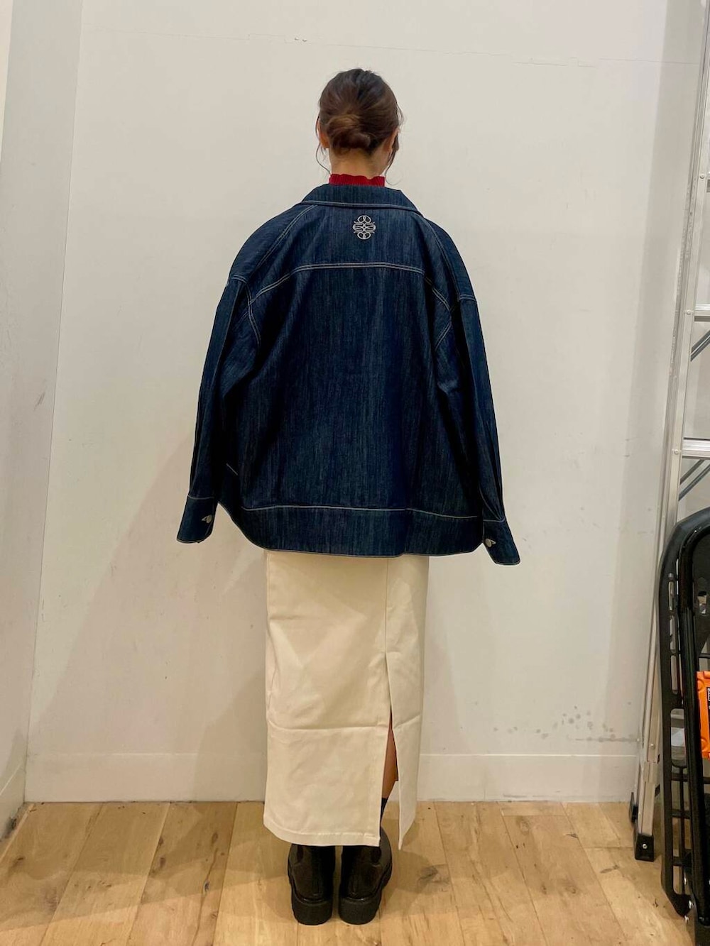 ブラック系のショルダーバッグ、レッド系のニット/セーター、ベージュ系のスカートを着用したレディースの秋コーディネートの3枚目の写真