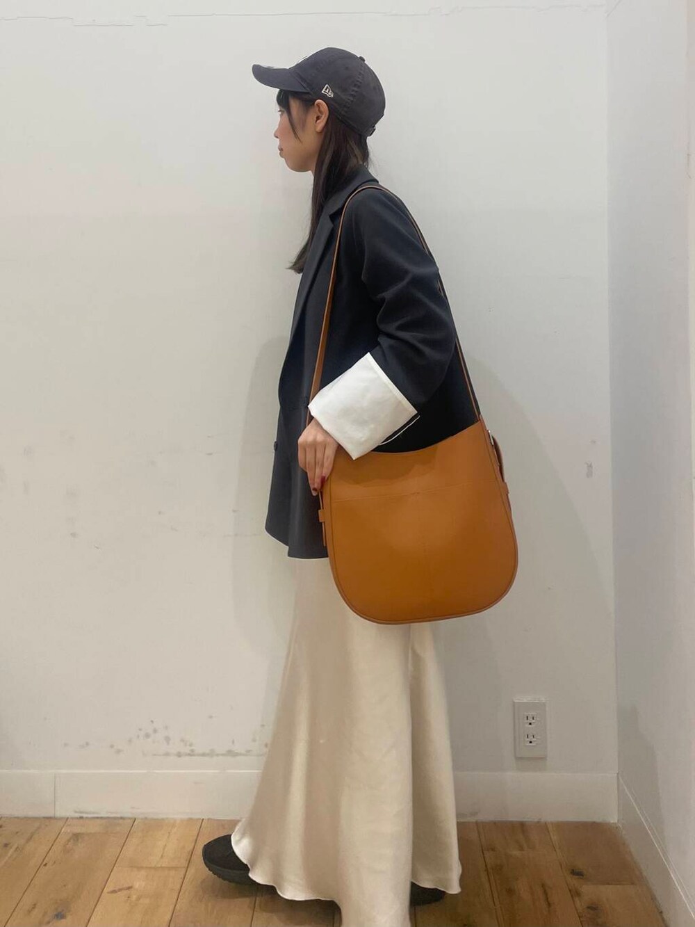 グレー系のテーラードジャケット、ブラック系のバレエシューズ、ブラウン系のショルダーバッグを着用したレディースの冬コーディネートの2枚目の写真